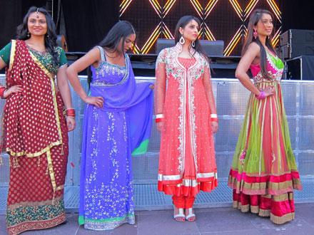 four women presenting various traditional outfits on stage